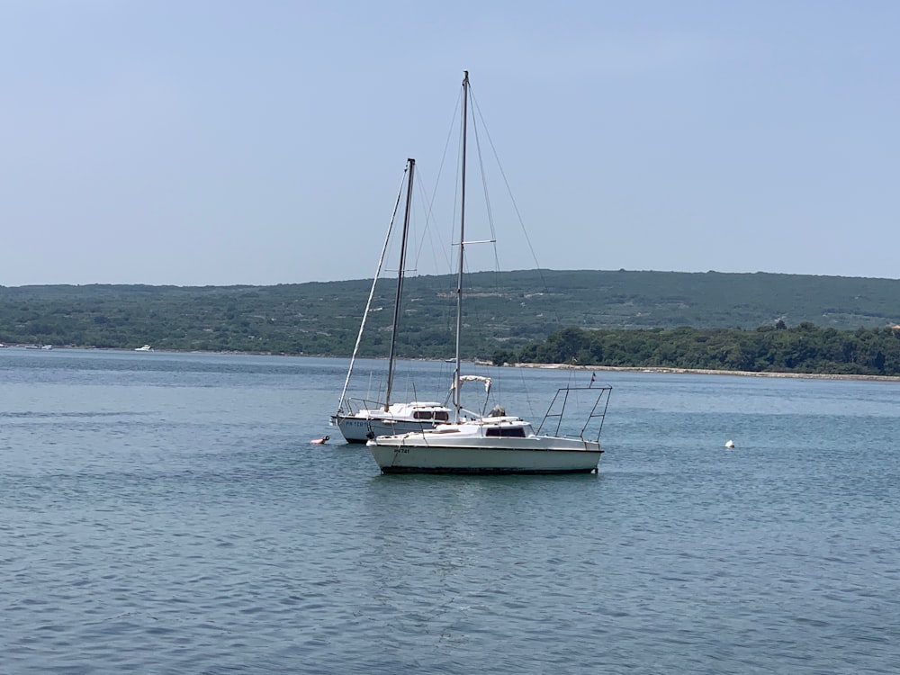 two yacht on calm body of water