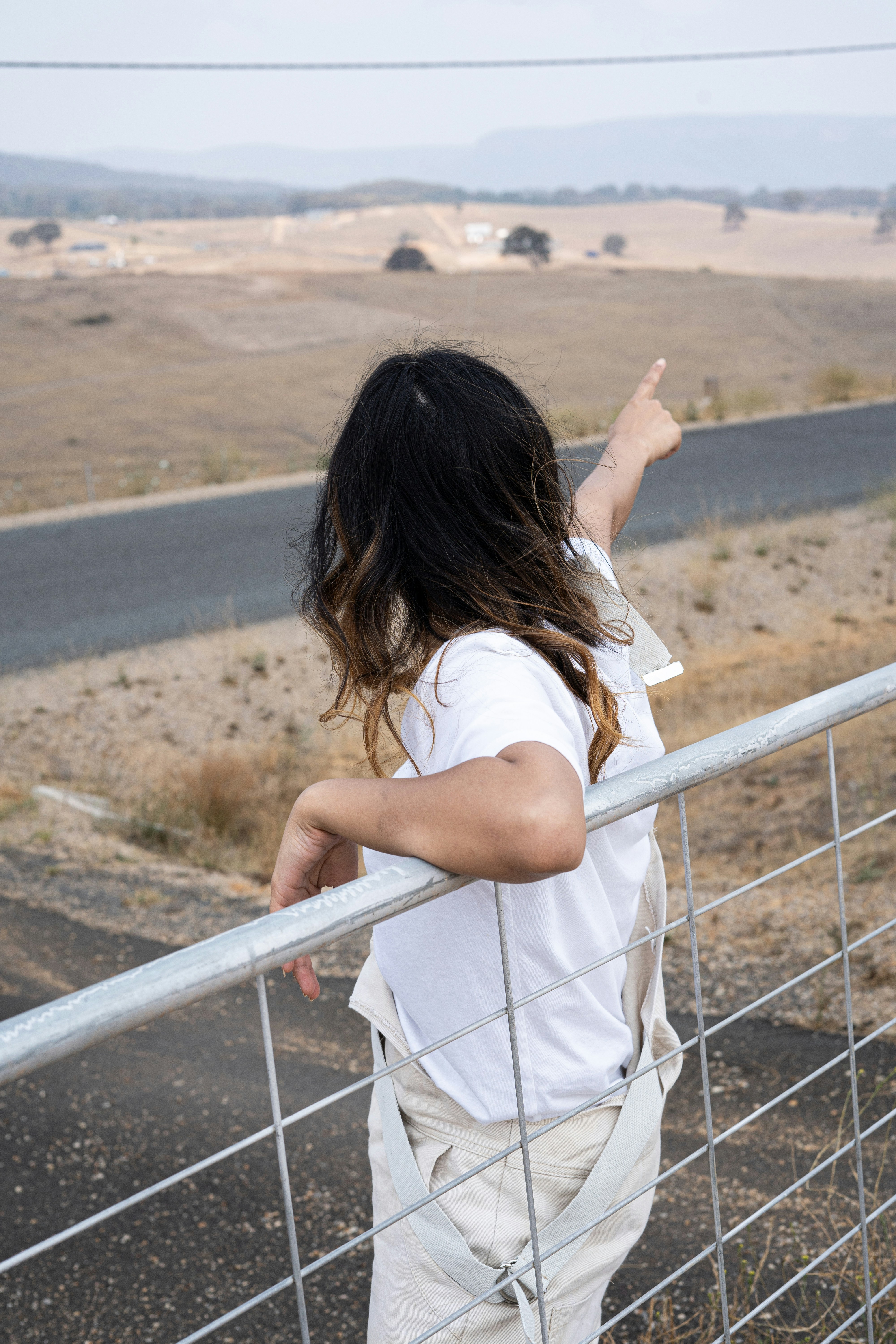 woman points her finger to the east side of the road