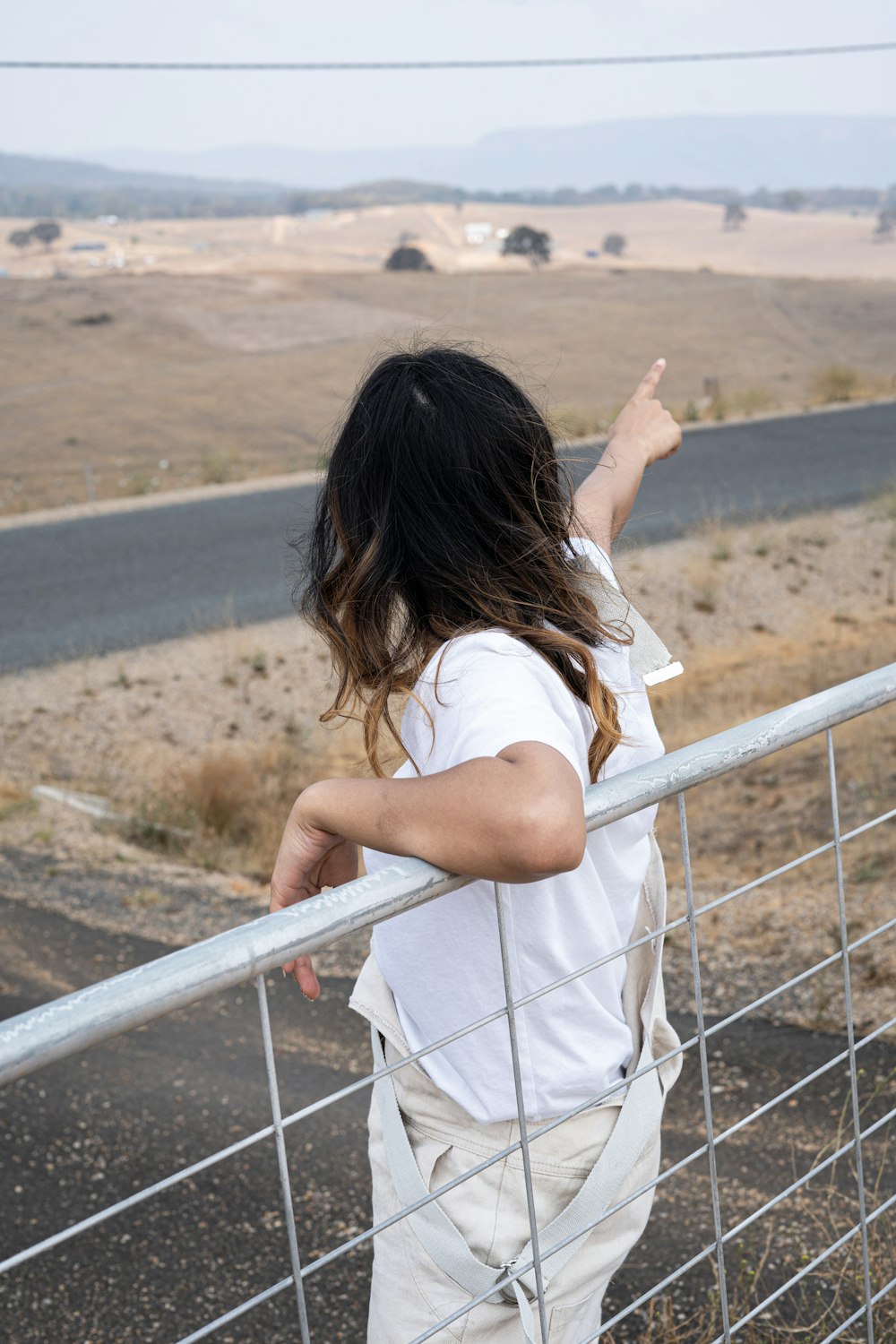 woman points her finger to the east side of the road