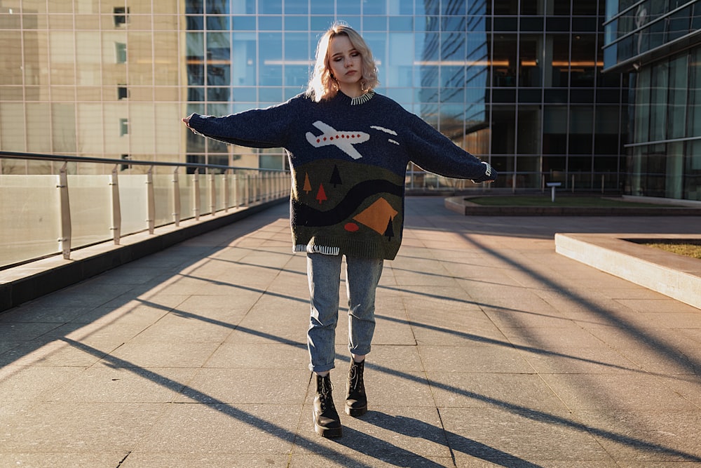 woman with wide arms open standing on cconcrete pavement