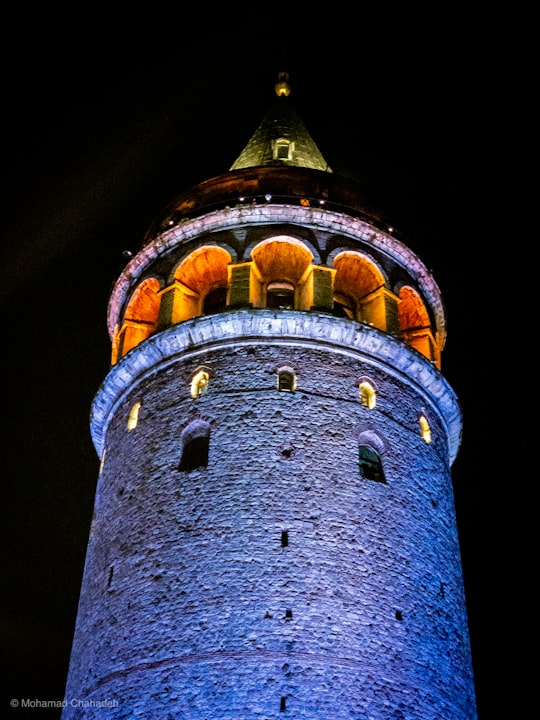 brown and white concrete tower during nighttime in Galata Tower Turkey