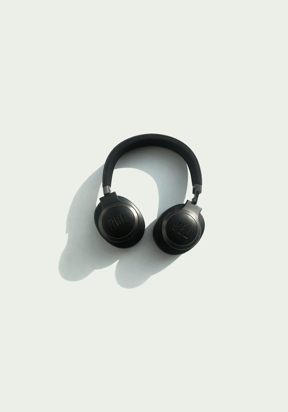 black JBL corded headphones on white panel
