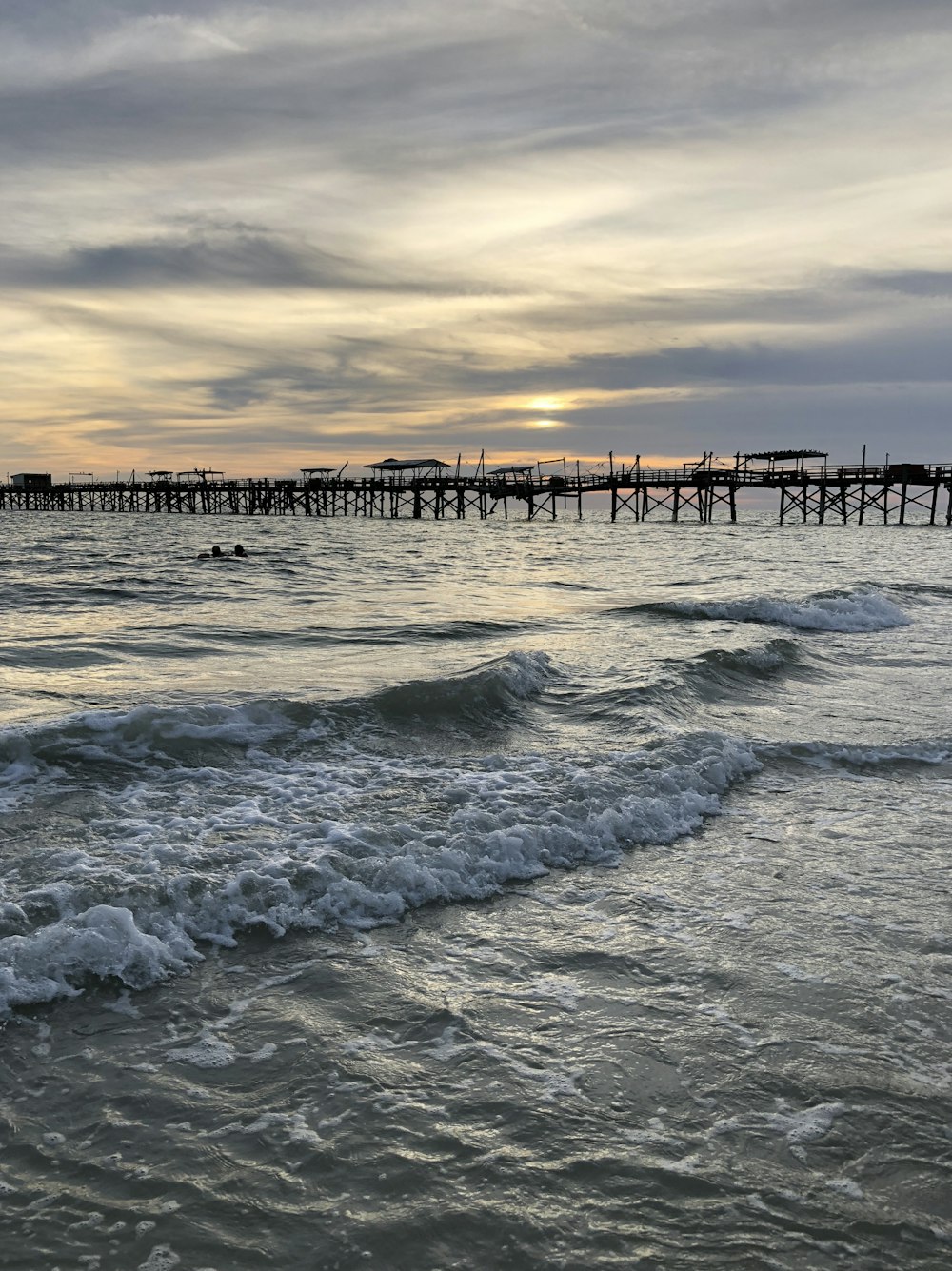 silhouette of dock bridge on seashore