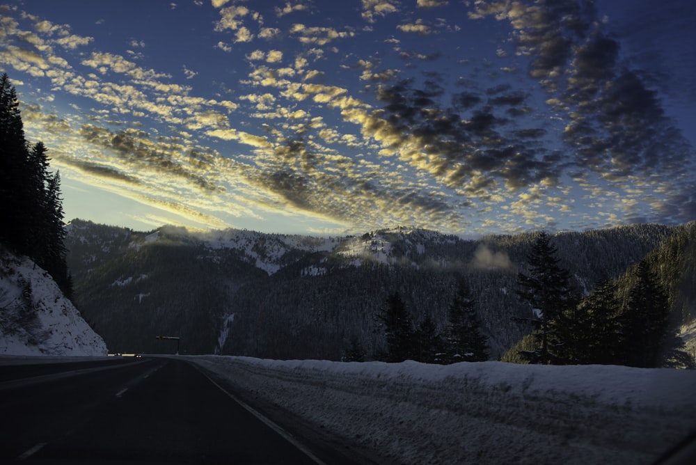 black pavement traffic road towards brown mountain