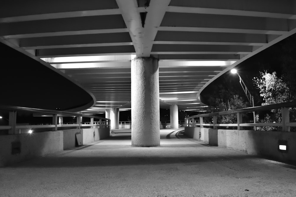 a black and white photo of a walkway at night