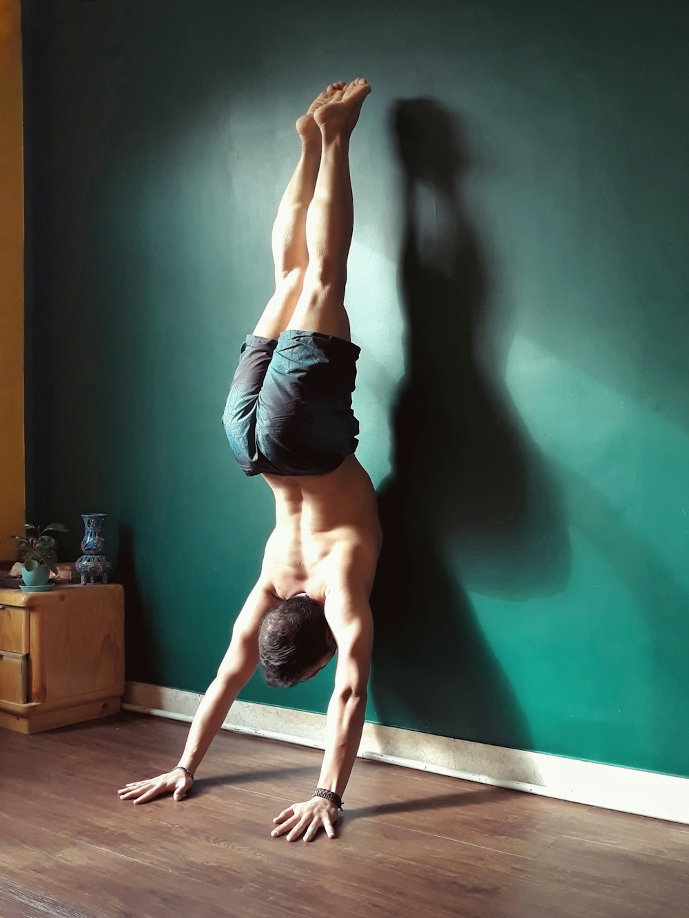 man doing stunt near green wall