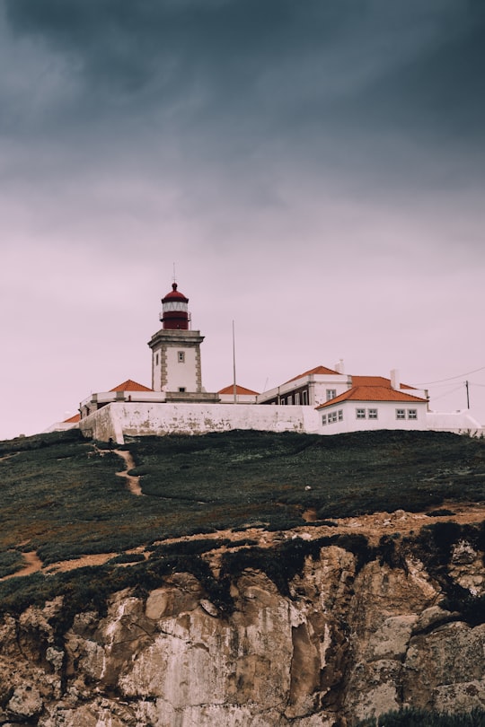 white and brown concrete building near cliff in Sintra-Cascais Natural Park Portugal