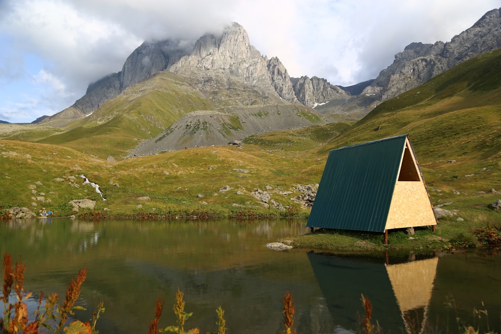 green and beige wooden hut on body of water