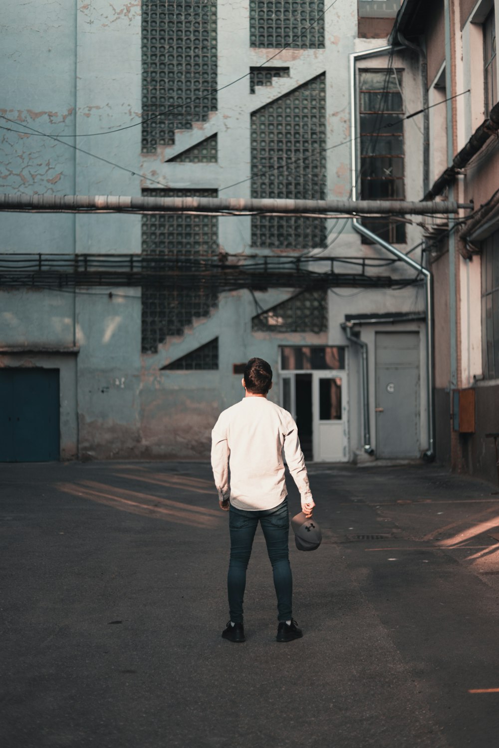 man standing near grey building