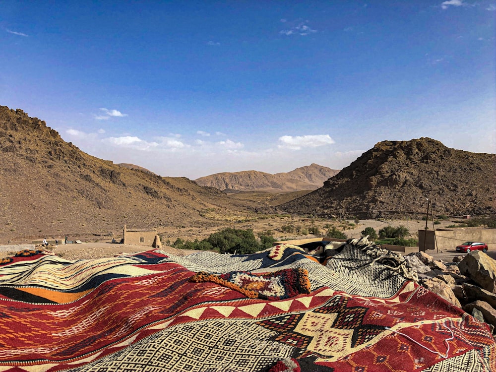 a pile of blankets sitting on top of a dirt field