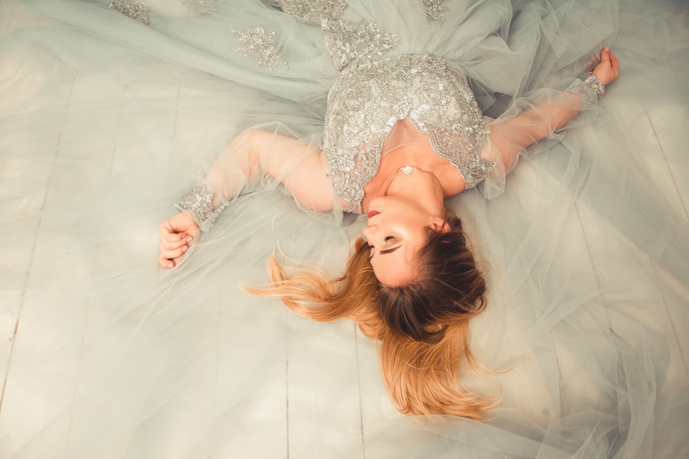 woman in gray V-neck dress lying down