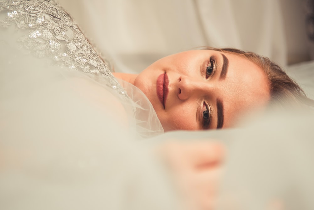 selective focus photography of lying down woman wearing gray top