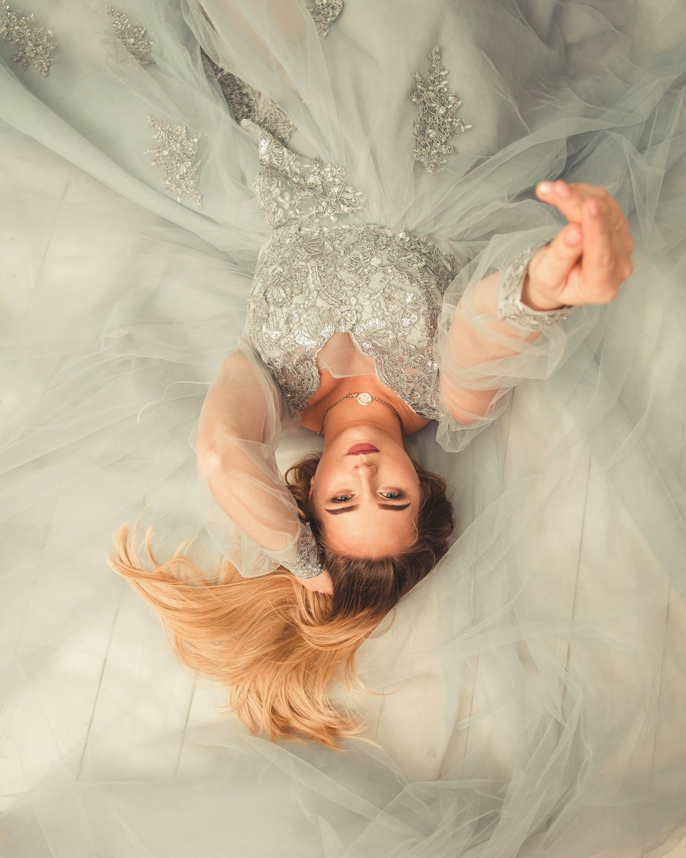 woman in wedding dress lying on bed