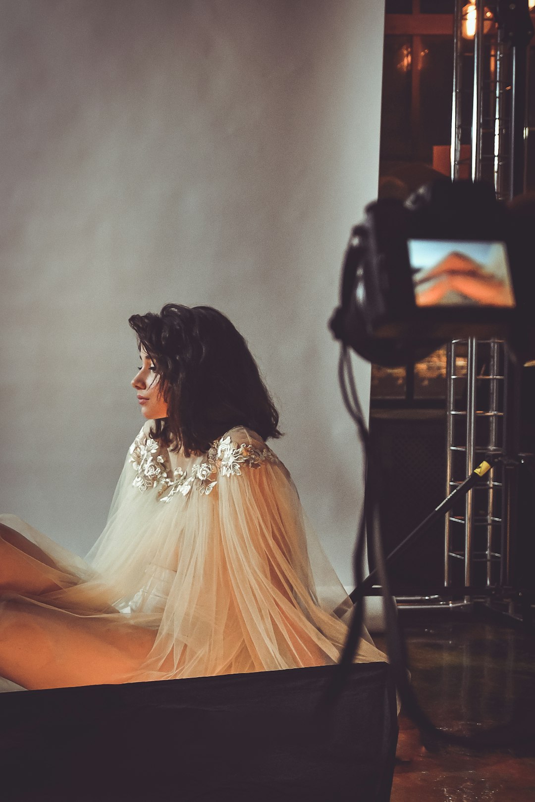 sitting woman wearing white lace dress with white background