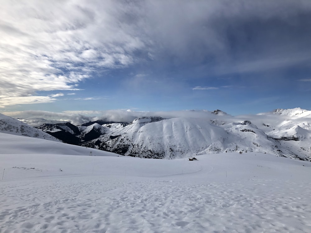 champ et montagne recouverts de neige sous ciel blanc et bleu