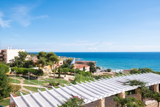 houses, buildings, and hotels near blue sea under blue and white sky in Tarragona Spain