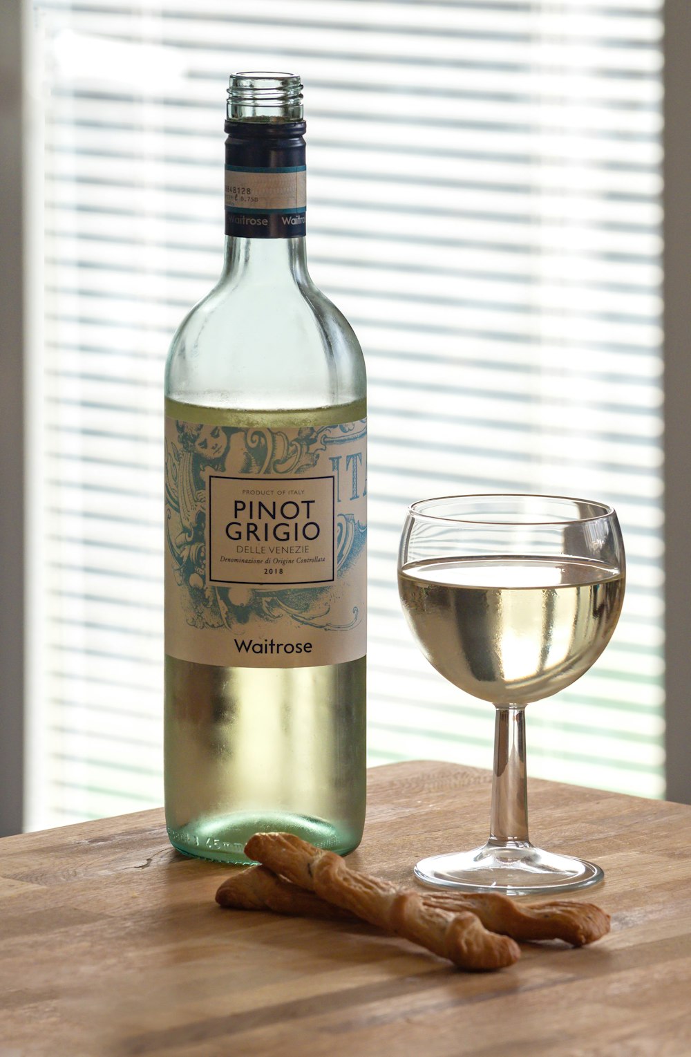 Waitrose pinot grigio near glass of wine and bread on a wooden table