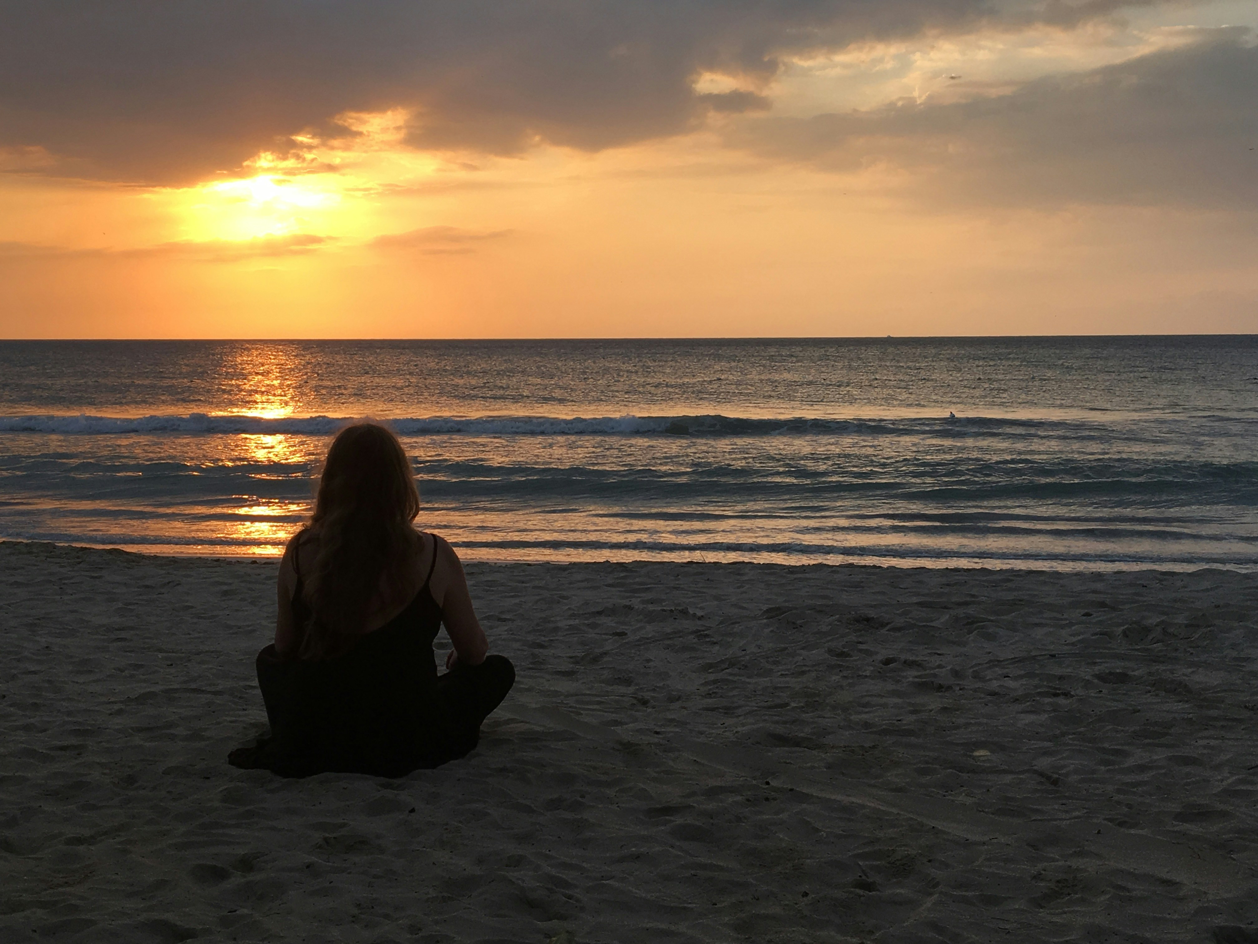 Biten bir ilişkiden sonra gelen iç huzuru ve özgürlüğü temsil eden, gün batımına karşı kollarını açmış veya derin bir nefes alan huzurlu bir kişi.
