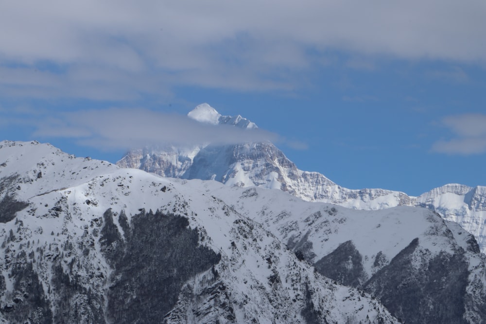 summit view of mountain covered with snow under white and blue sky