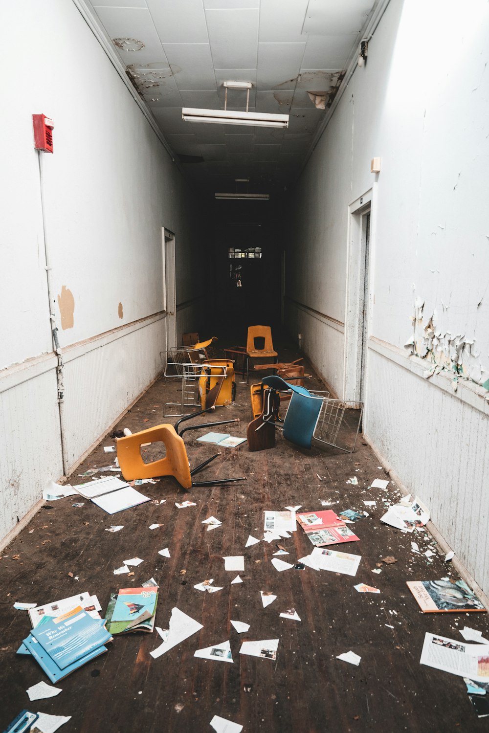 床に椅子と書類が置かれた廊下