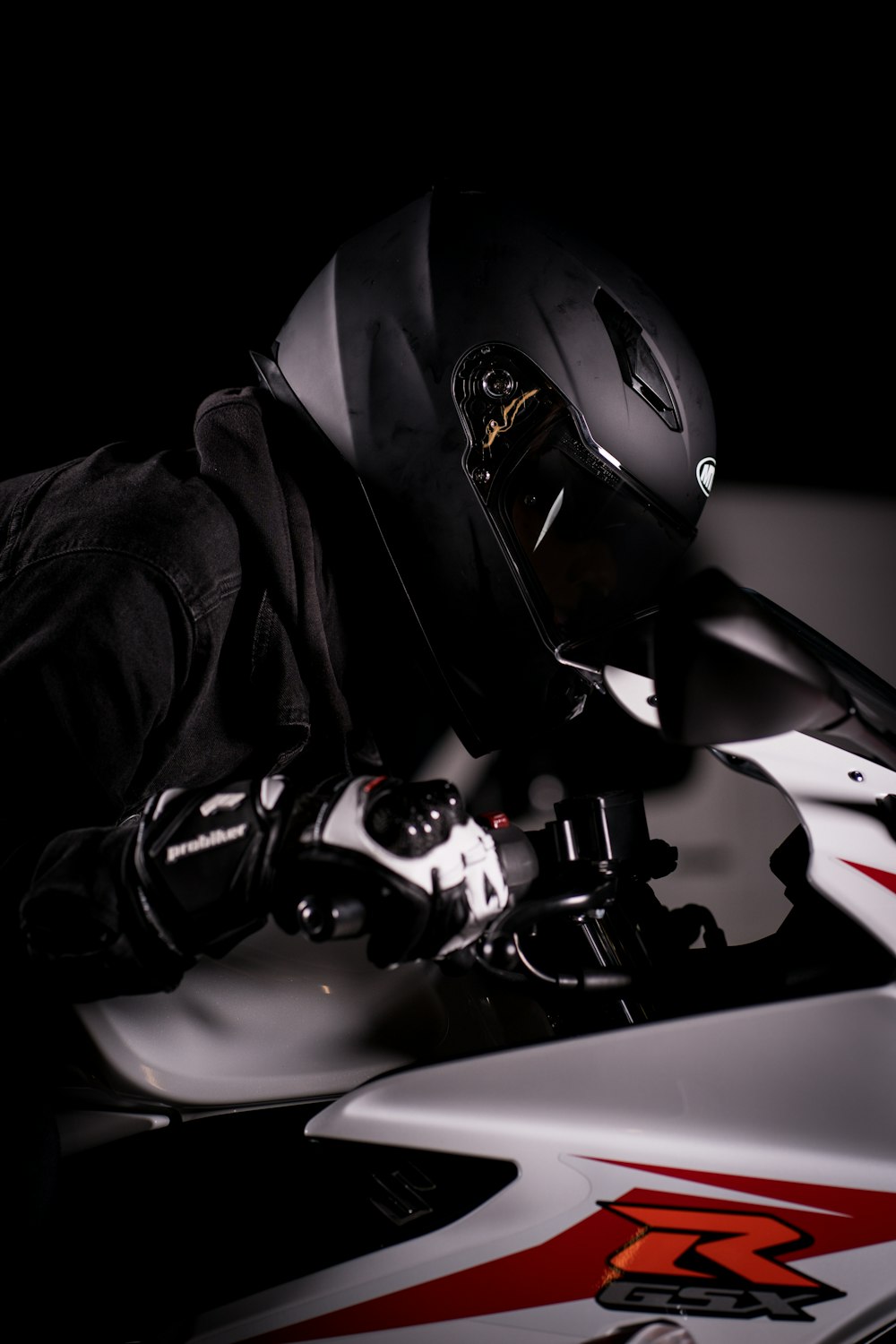 a person wearing a helmet laying on a motorcycle