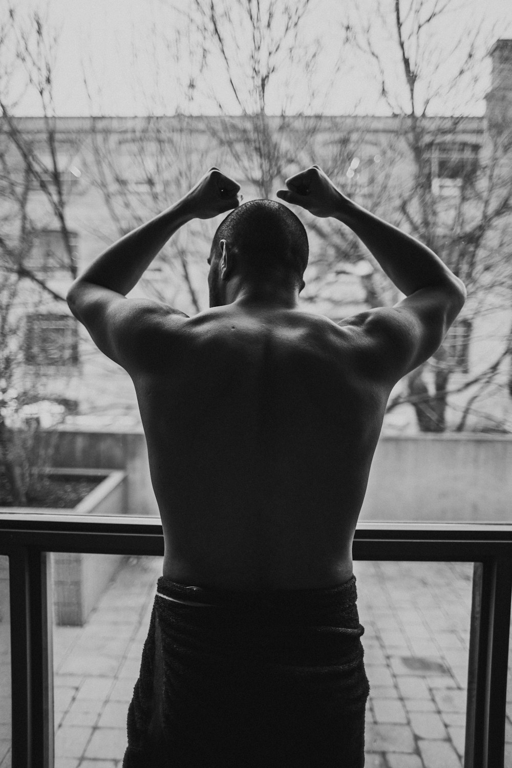 topless man standing near window