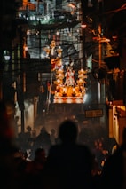 Nighttime view of the carnival procession illuminated by vibrant lights and festive floats.