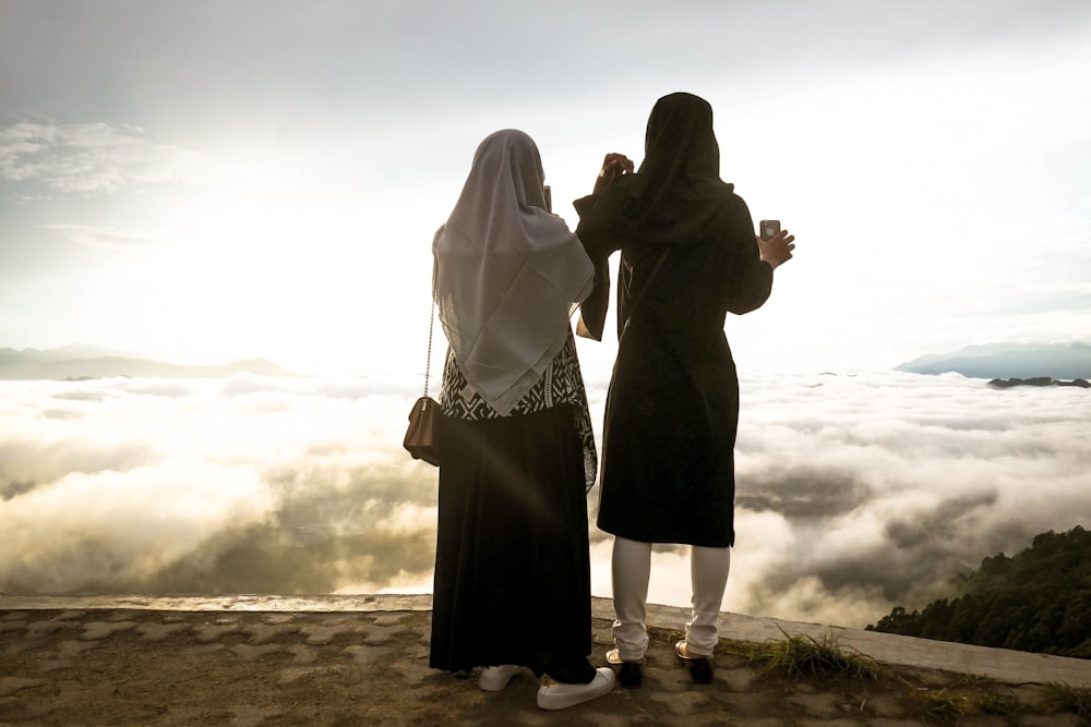 two woman standing on cliff