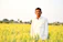 A happy farmer standing in a lush green field.