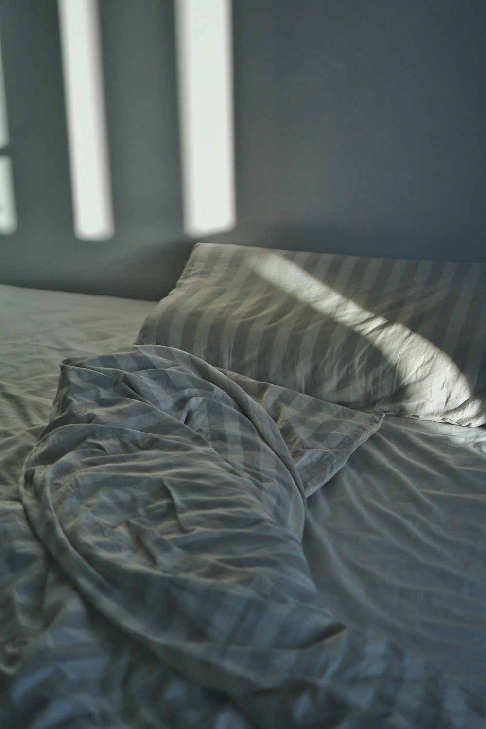 Manta a rayas y almohada en la cama