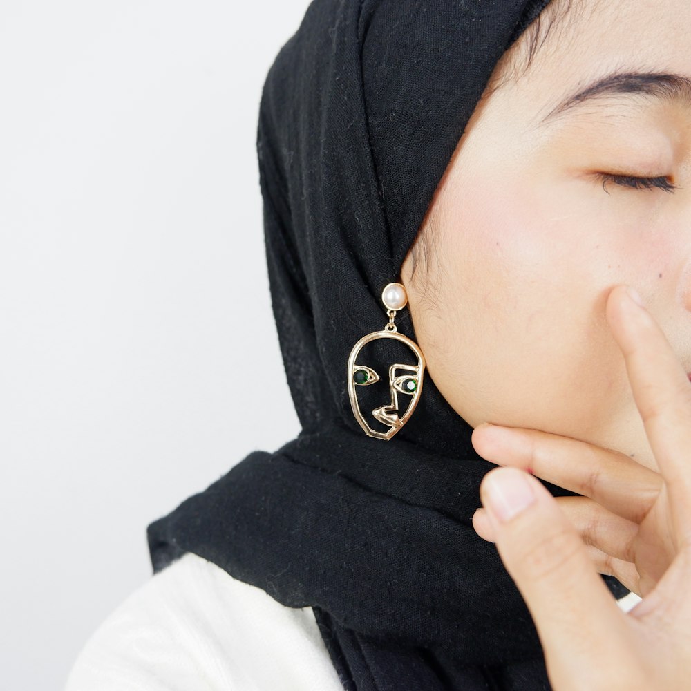 woman wearing hijab and gold-colored earring