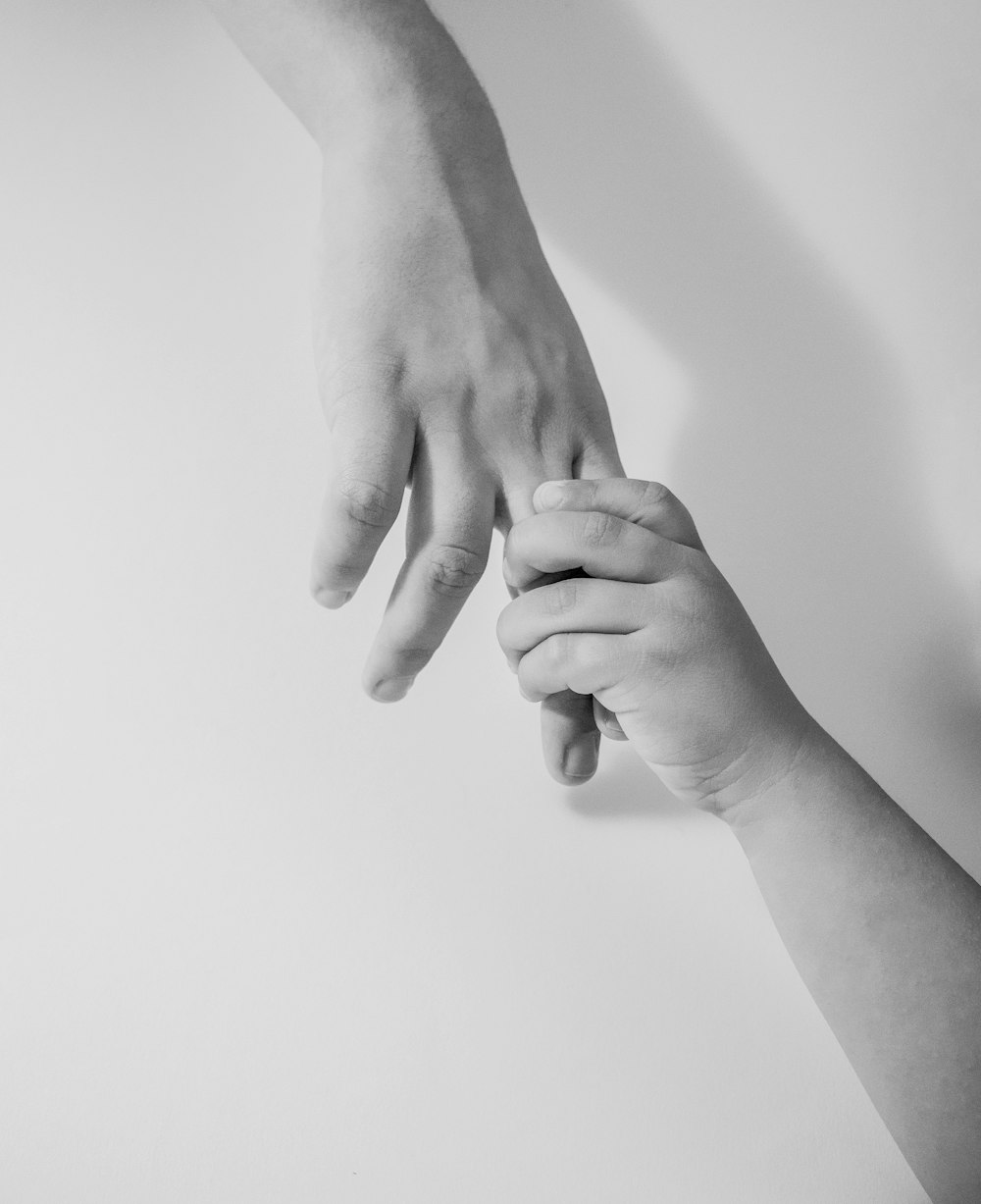 grayscale photo of to hands