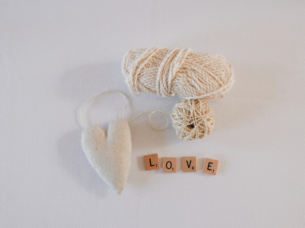 white yarns beside white heart accessory