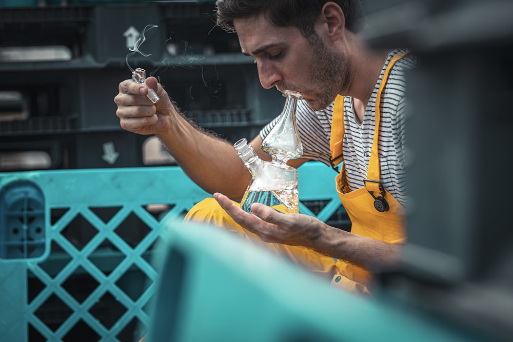 hombre usando un dispositivo de vidrio para fumar