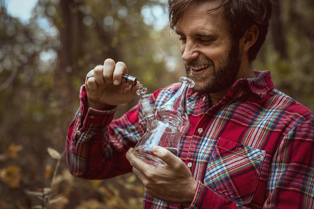 smiling man using clear glass bong