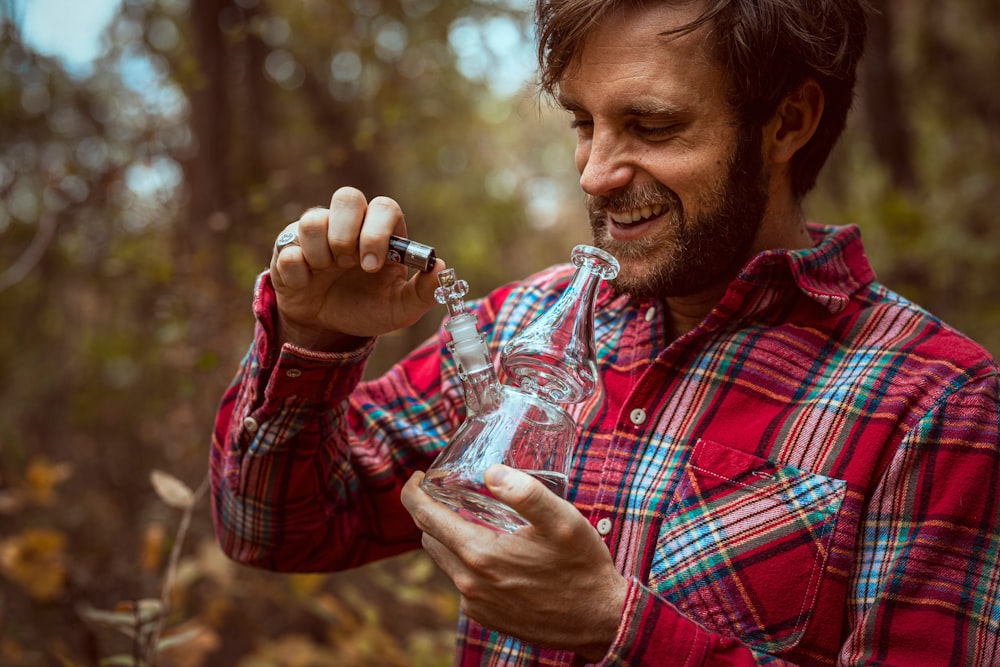 smiling man using clear glass bong