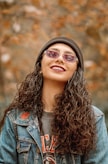 woman smiling wearing denim jacket and sunglasses
