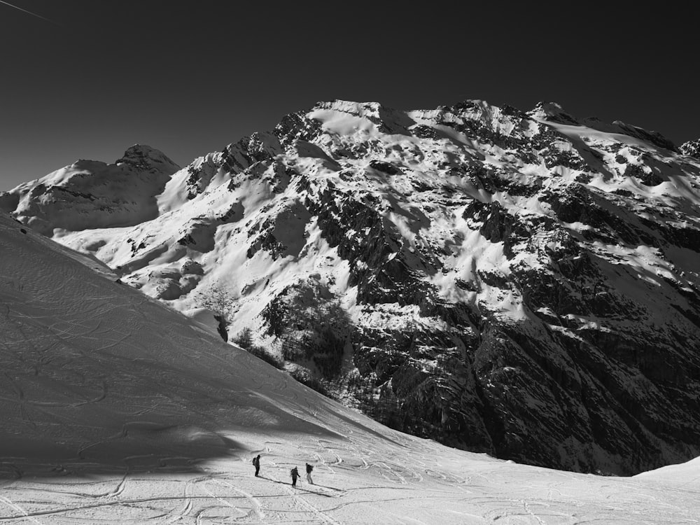 three person standing on mountain with snow