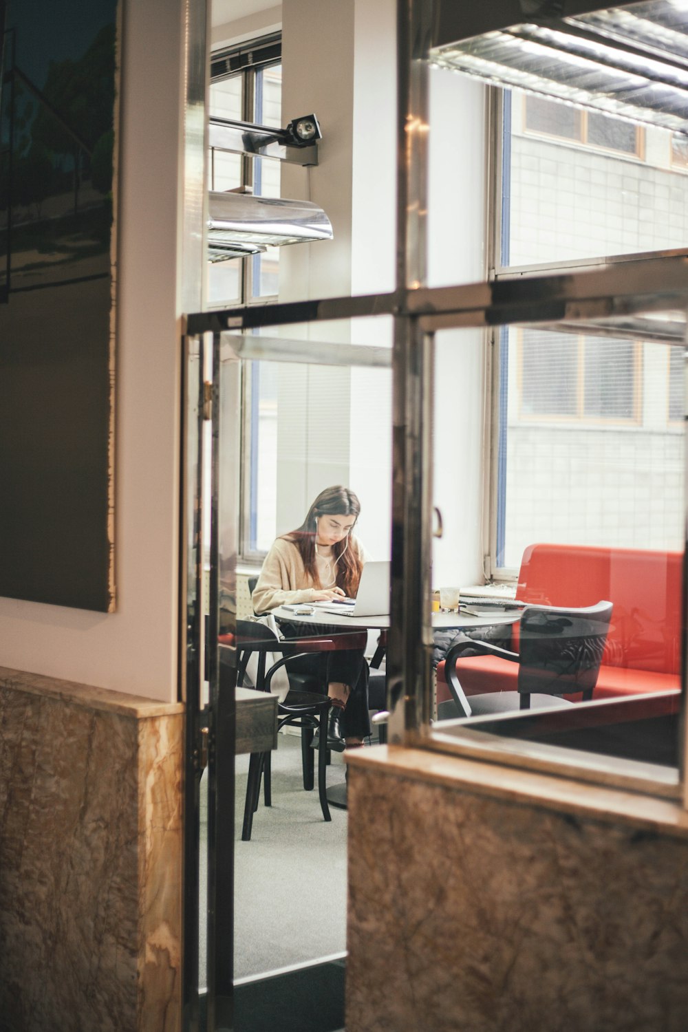 woman sitting and using laptop indoors