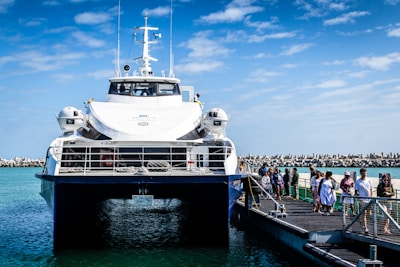 white and blue ship near wooden dock