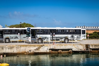 A 25-seat Rosa bus parked near Kiama Blowhole with coastal cliffs in the background