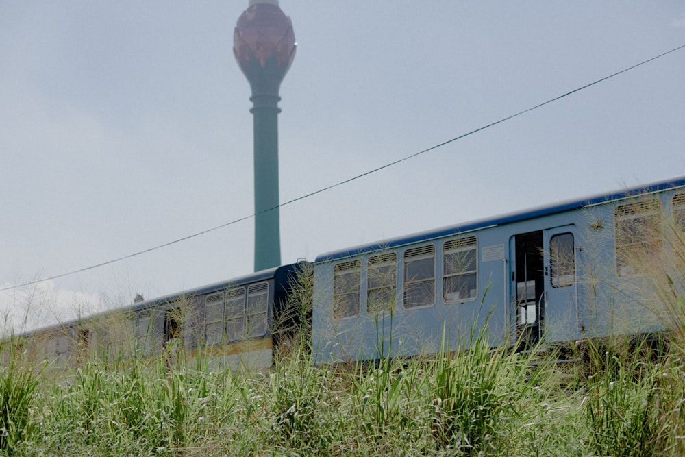 blue train beside grass during day