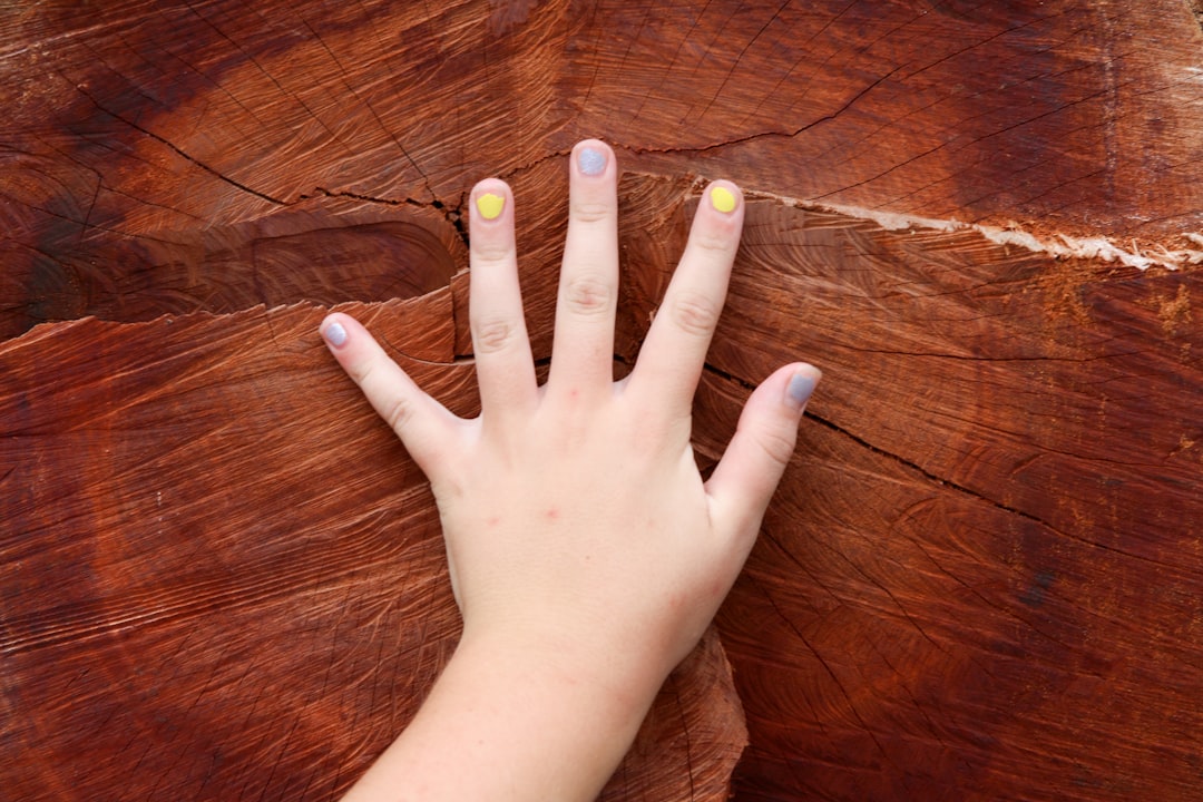 person with yellow and blue nail polish