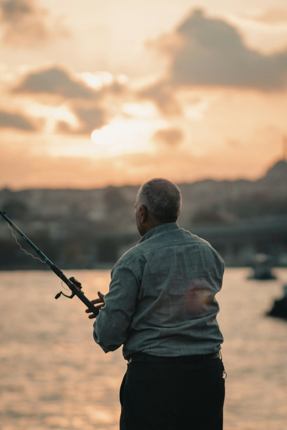 a man standing on a dock holding a fishing pole