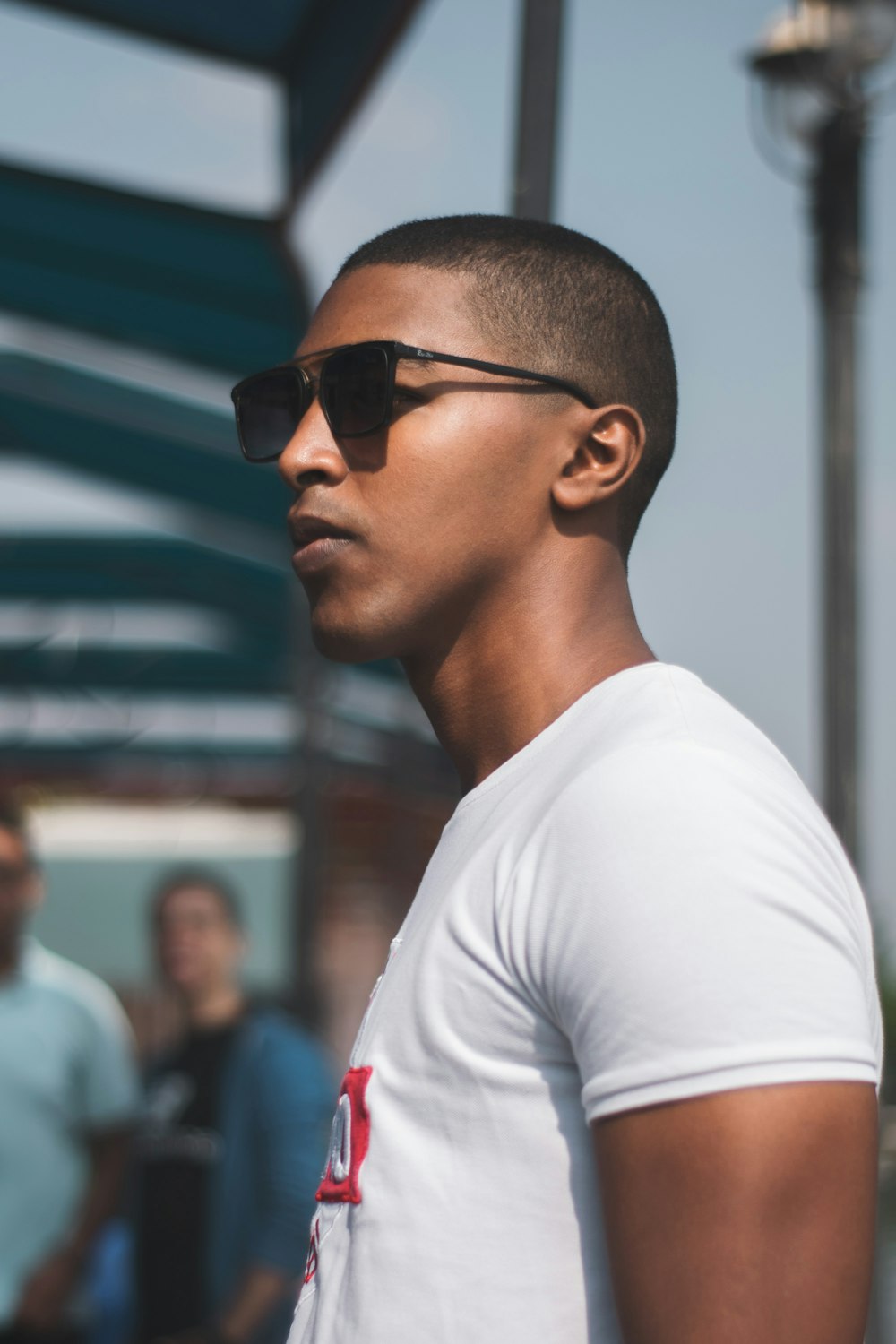 man wearing black sunglasses near people