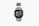 A silver digital wristwatch with a rectangular face displaying the time, world time map, and additional features. The watch has a metal strap and a robust, classic design.
