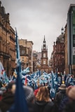 people on street holding scotland flag