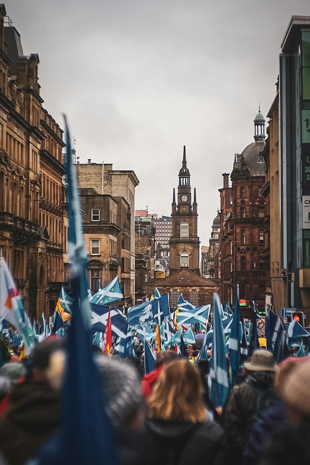 people on street holding scotland flag