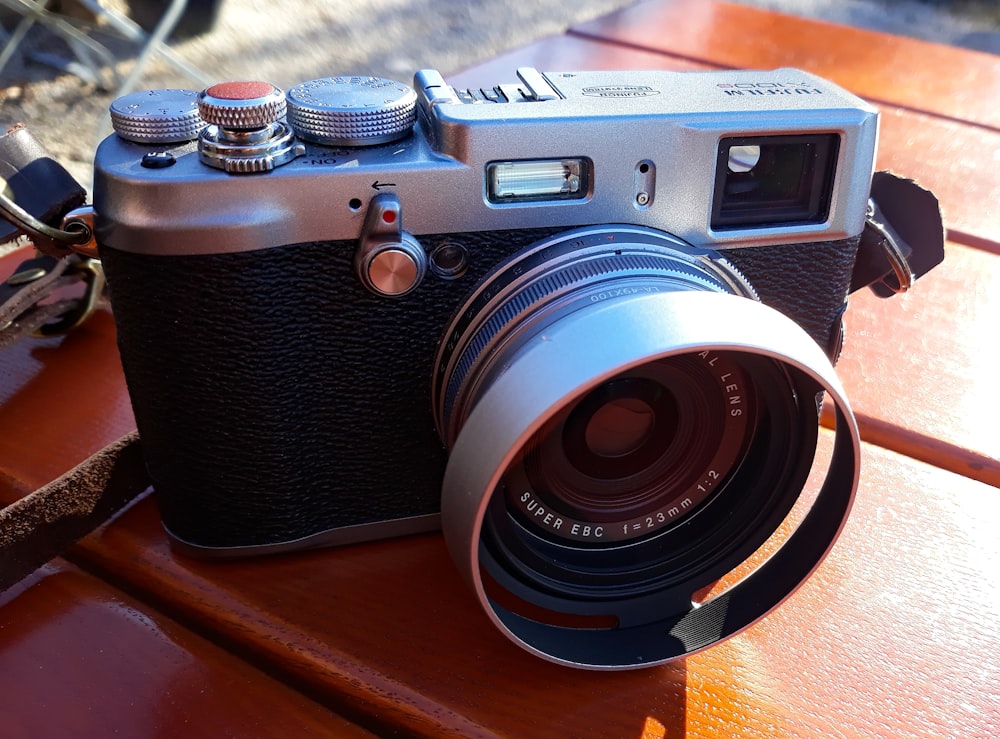 black and silver camera on wooden surface