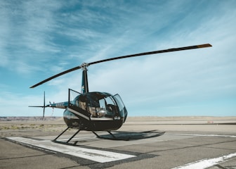 black helicopter on railway under white and blue sky